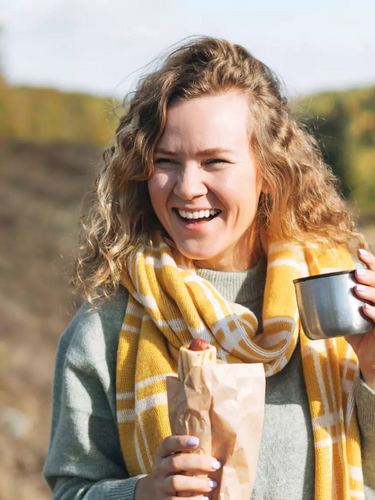 Glückliche Frau mit Thermobecher